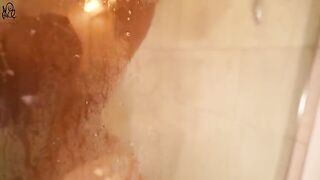 A young beautiful woman caresses her body with water in the shower
