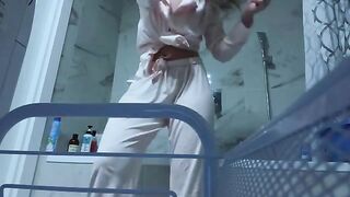 A petite girl caresses her slim body and gets wet in the bathroom