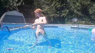 Redhead in red bikini diving in the pool