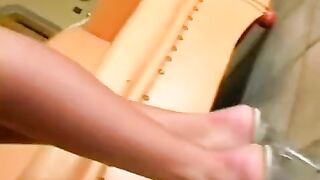 Beautiful brunette caresses herself in a leather chair, showcasing her amazing ass
