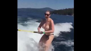 Topless girl skillfully rides on the water skiing