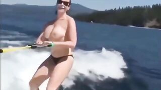 Topless girl skillfully rides on the water skiing