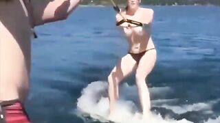 Topless girl skillfully rides on the water skiing