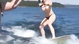 Topless girl skillfully rides on the water skiing