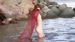 A sexy girl with small boobs gets wet in the rain in the forest