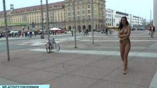 A naked chick is walking on the city streets