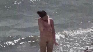 Nudist couple enjoying romantic sex on the beach