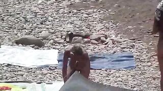Nudist couple enjoying romantic sex on the beach