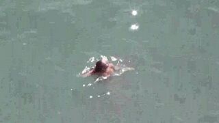 A pair of naked people are having fun on the sea