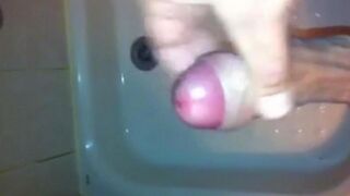 The kid caresses his dick with his hand in the shower