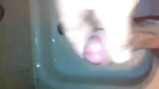 The kid caresses his dick with his hand in the shower