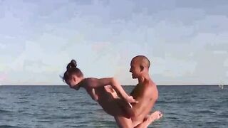 Acrobats have fun on the naked beach