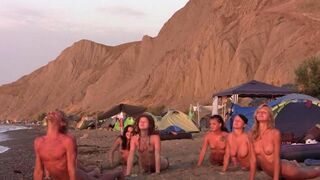 A group of naked people play volleyball on the beach, showcasing their freedom