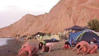A group of naked people play volleyball on the beach, showcasing their freedom
