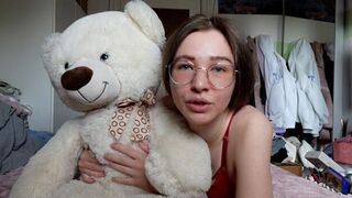 A cute girl has fun with her best friend, a big fluffy teddy bear