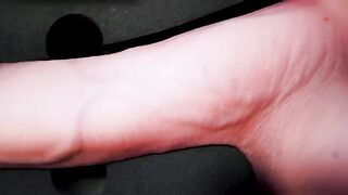 A girl caresses herself with a dildo, imitating the actions of a man
